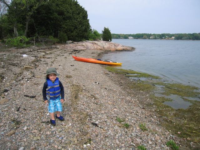 Boy on the beach kayaking 